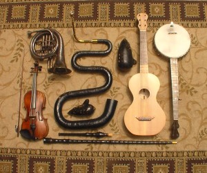 Some of the instruments played by the Oregon Trail Trio.  Top row, left to right: ballad horn, serpent, bass ocarina, guitar, banjo; second row: violin, tenor ocarina; third row: flageolet, fourth row: walking stick recorder